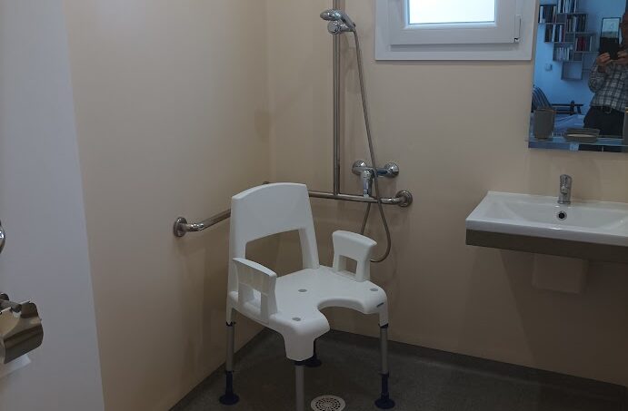 Salle de bain accessible PMR fauteuil roulant chaise douche barres d'appui