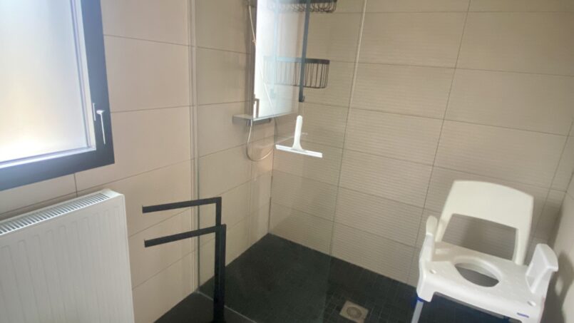 salle de bain PMR accessible aux fauteuils roulants, douche italienne entrée large et siège douche