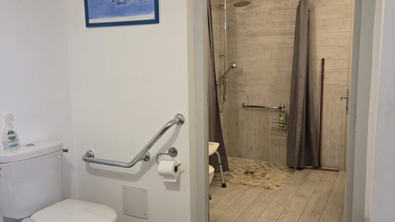 WC avec barre d'appui et espace de transfert pour les PMR en fauteuil roulant