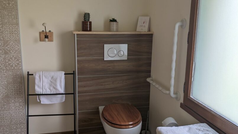 WC avec barre d'appui et espace de transfert pour les Personnes à Mobilité réduite (PMR) en fauteuil roulant
